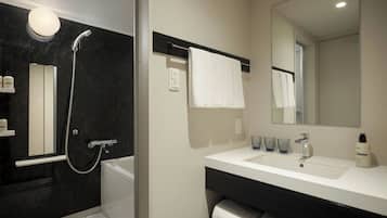 Un baño moderno con bañera, ducha, lavabo y espejo.