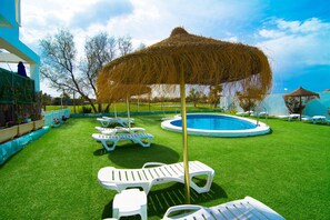 A pool area with white lounge chairs and a thatched umbrella. - Roquetas Beach & Playa Serena Golf (Roquetas de Mar)