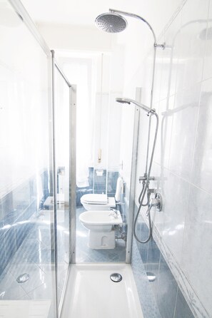 A modern bathroom with a glass-enclosed shower, a white toilet, and a sink. - Alessia's Flat - Breno 1 (Milan)