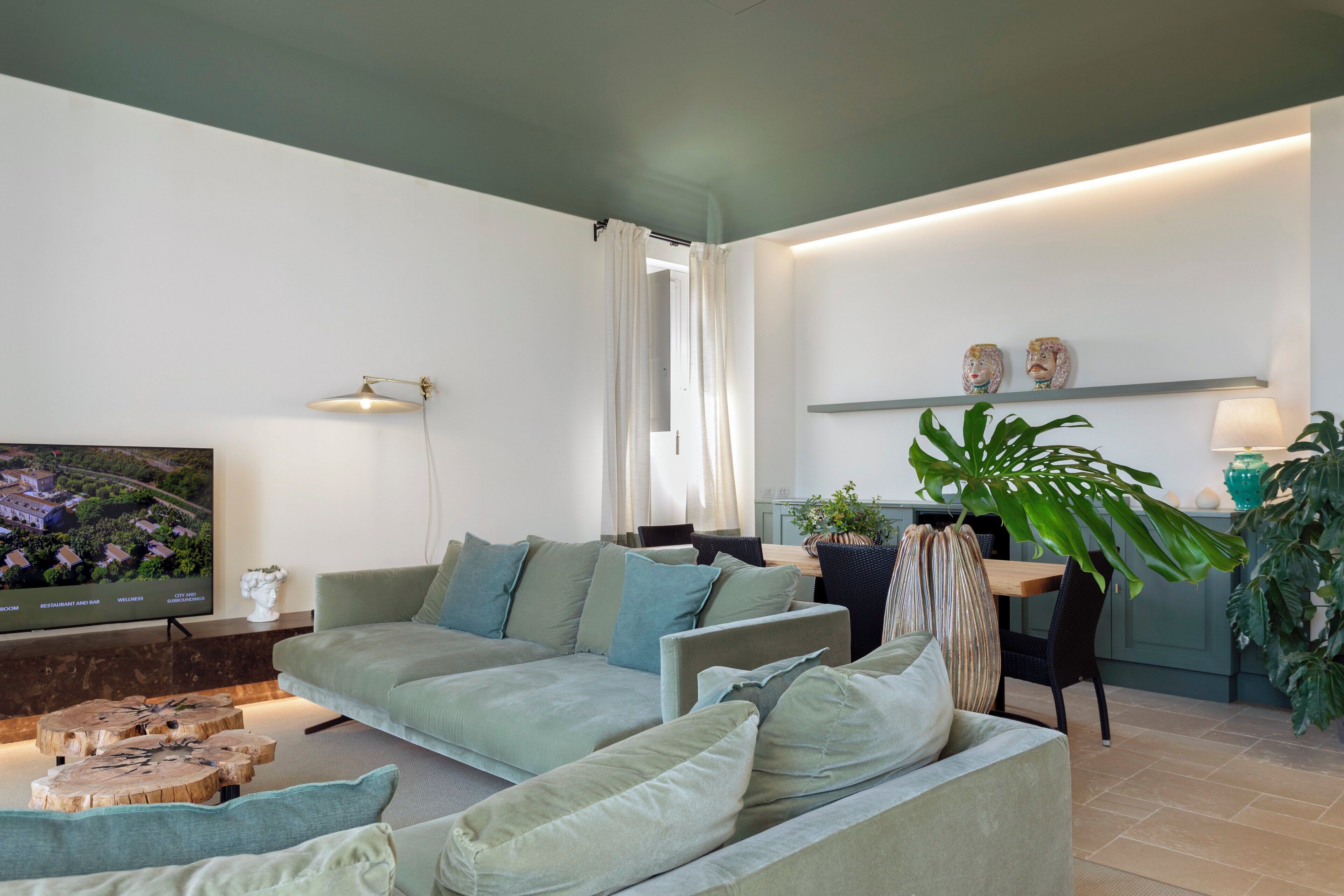 Una sala de estar moderna con un sofá, una mesa de centro y un televisor que muestra un paisaje.