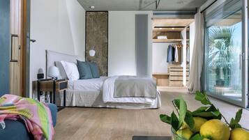 Quarto moderno com cama, mesa de cabeceira, luminária e vista para um armário e área externa.