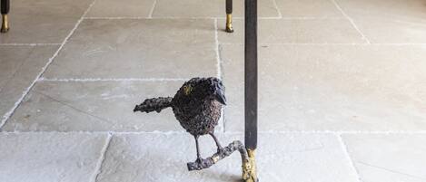 A cozy room with a sofa, a coffee table, and a decorative bird sculpture.