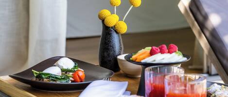 A breakfast tray with food items and a vase with yellow spherical objects.