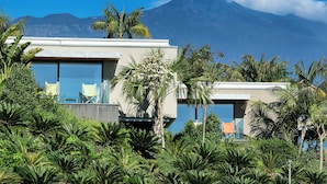 Un bâtiment moderne doté de grandes fenêtres et offrant une vue sur une montagne.
