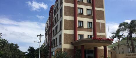 Um hotel de vários andares com uma entrada notável e uma placa que diz 'Grange Gardens'.