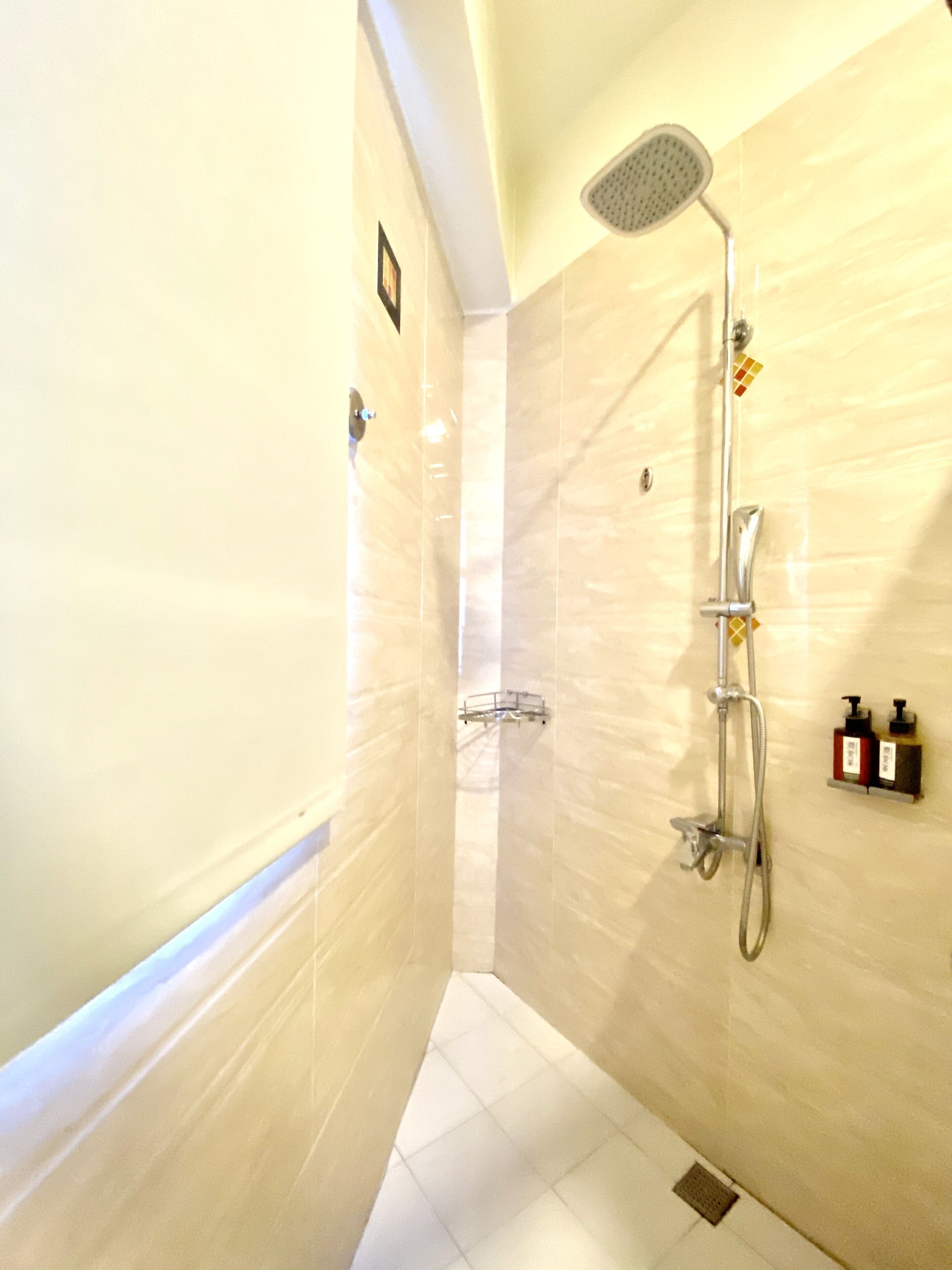 A modern bathroom with a shower, a toilet, and a sink.