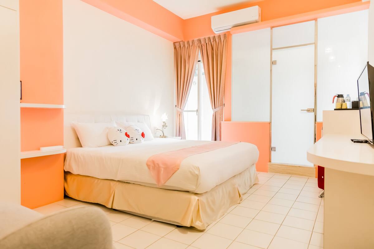 A bedroom with a bed, a bedside table, a TV, and a wardrobe.