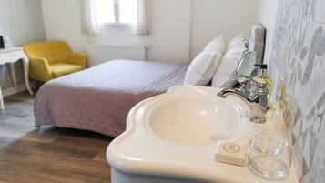 Ein Badezimmer mit einem weißen Waschbecken, einem Spiegel und einem Fenster.