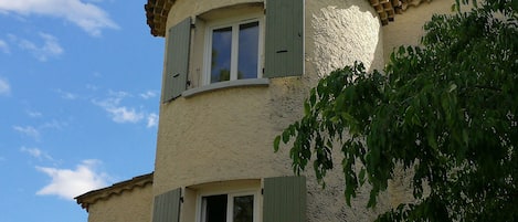 A two-story building with a textured facade and a tiled roof.