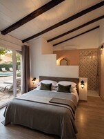 Un dormitorio con cama, dos luces empotradas, una ventana y zona de ducha.