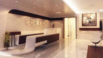 Experience the sleek, modern reception area with a polished floor and a striking artwork above the central desk.