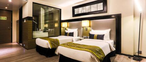 A hotel room with two beds, a large mirror, and a modern design.