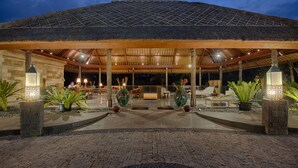 Un espace extérieur abrité, aménagé avec des sièges et des plantes en pot, probablement une terrasse ou un coin salon.