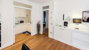 Una cocina moderna con armarios blancos, un microondas y un tapete colorido.