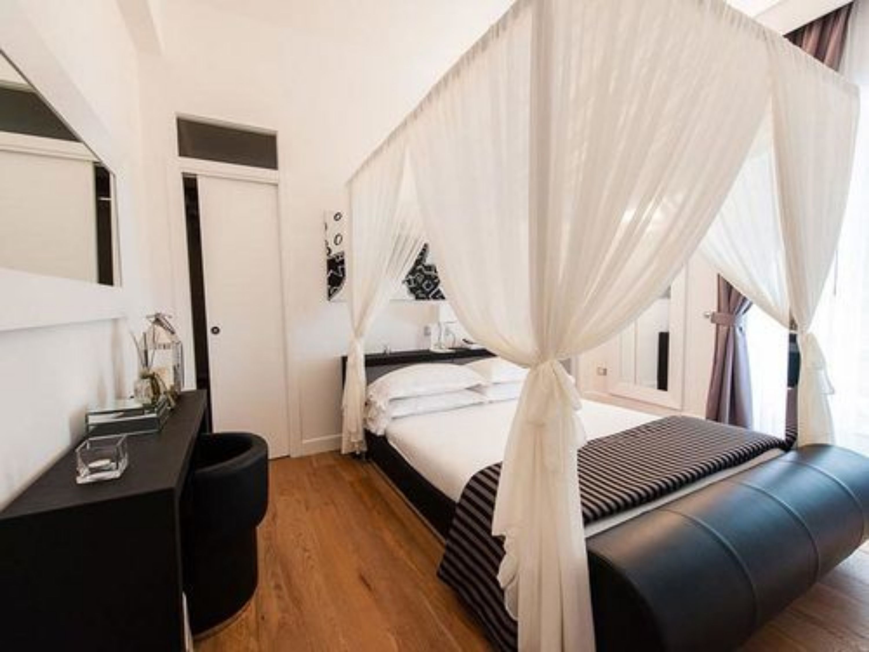 A bedroom with a bed, a desk, and a chair.