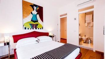 Ein Hotelzimmer mit Bett, einem Bild an der Wand und einem durchgegangenen Badezimmer.