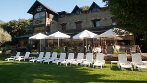 A hotel with outdoor seating and a stone facade. - Florido Hotel (Sort)