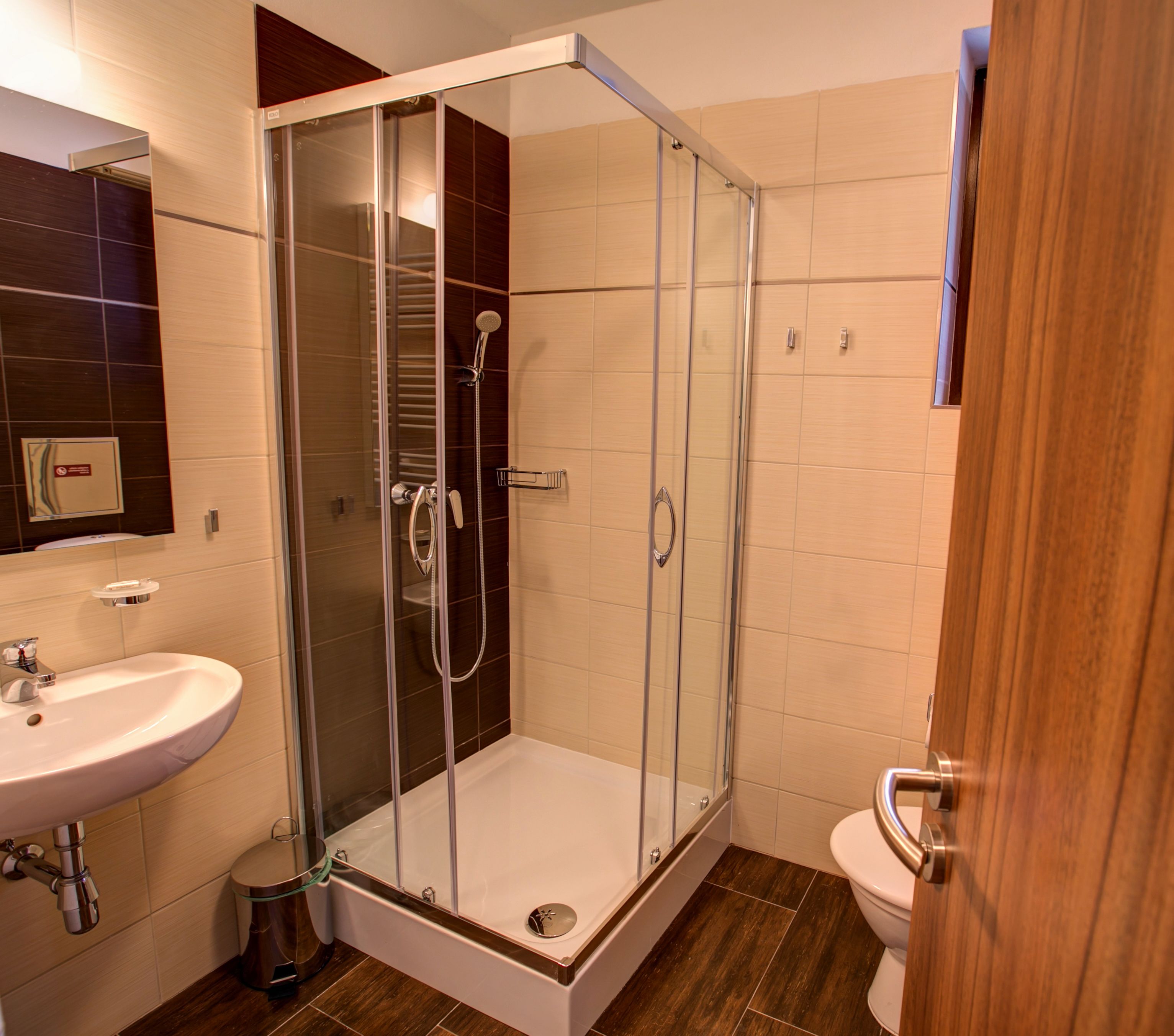Un baño moderno con ducha de vidrio, lavamanos e inodoro.