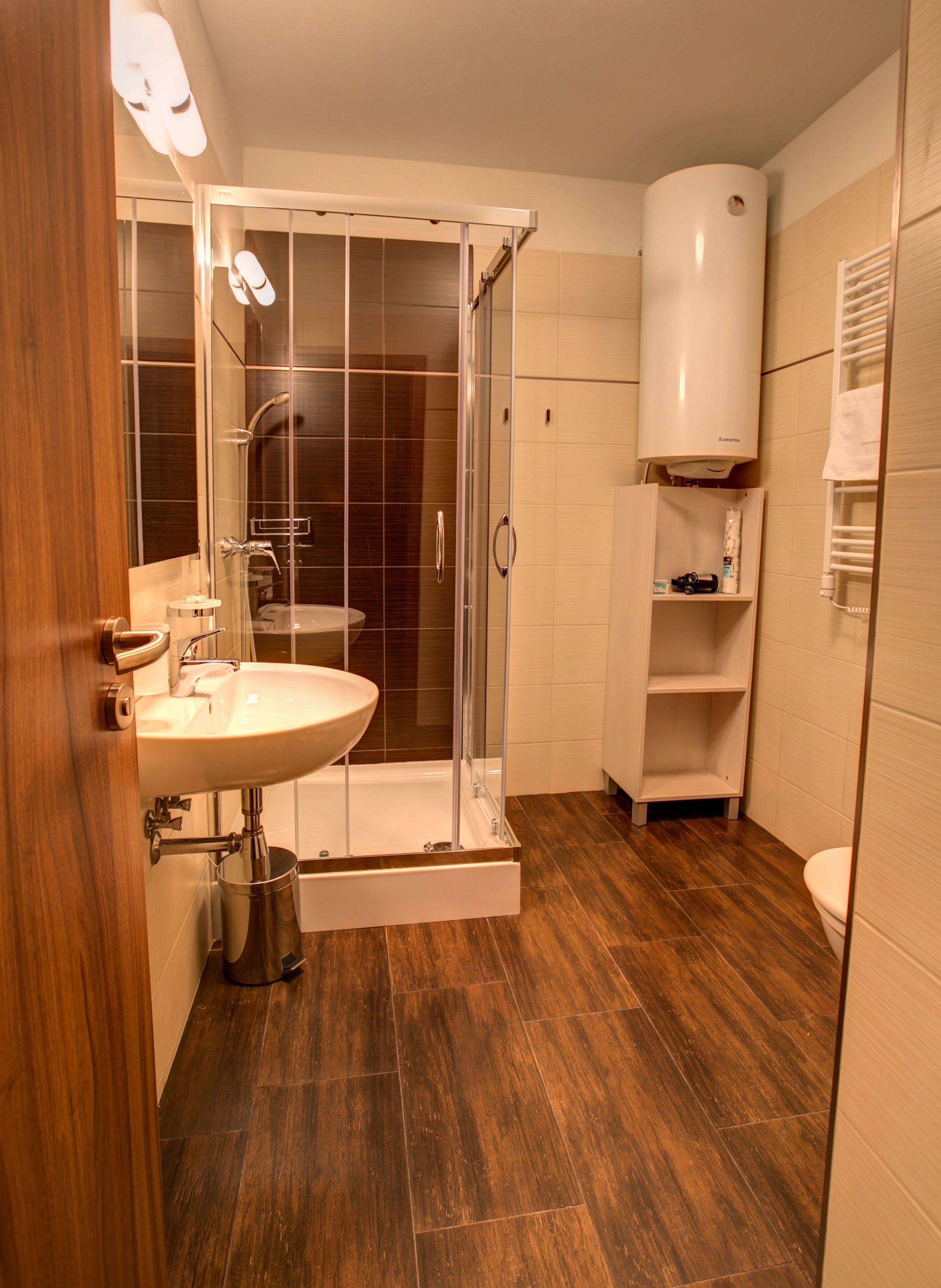 Un baño moderno con ducha de vidrio, lavamanos y retrete.