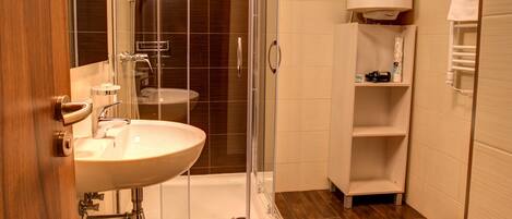 Un baño moderno con ducha de vidrio, lavamanos y retrete.