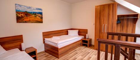Um quarto com cama de madeira, guarda-roupa de madeira e um quadro na parede.