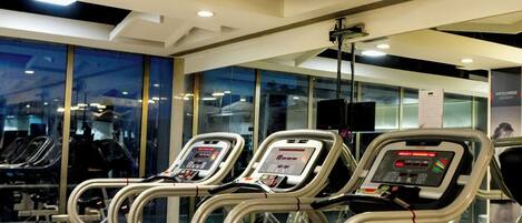Een fitnessruimte met loopbanden, trainingsapparatuur en een modern design.
