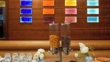 A hotel reception area with a wooden wall displaying a 'No Smoking' sign and a color-coded menu board.