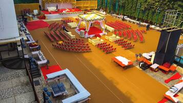 A large indoor venue with a central stage, multiple seating areas, and a tiled floor.