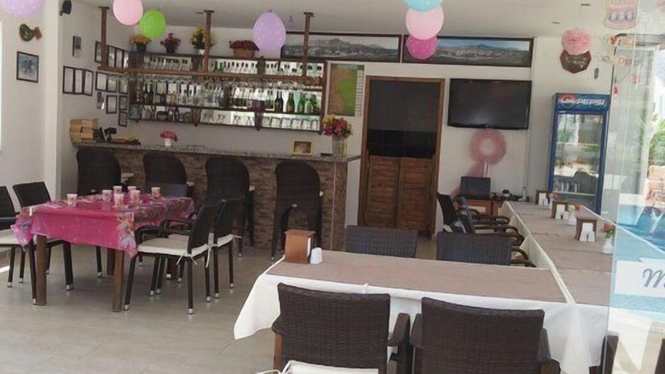 A restaurant with a bar area, dining tables, and chairs.