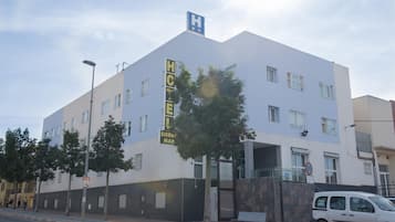Un hotel modern amb un senyalitzador destacat que diu 'HOTEL', un símbol d'hospital i un senyalitzador que diu 'SIERRA MAR'.