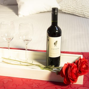 A bottle of El Potro Frison wine, two empty wine glasses, and a bouquet of red roses on a tray. - Hotel Duhoux Leeuwarden (Wirdum)