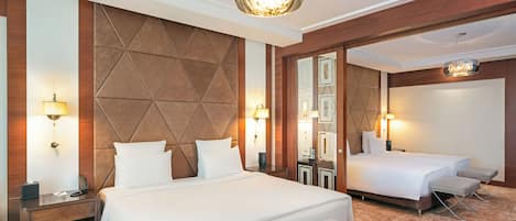 A hotel room with a large bed, a smaller bed, a bench, and a mirror.