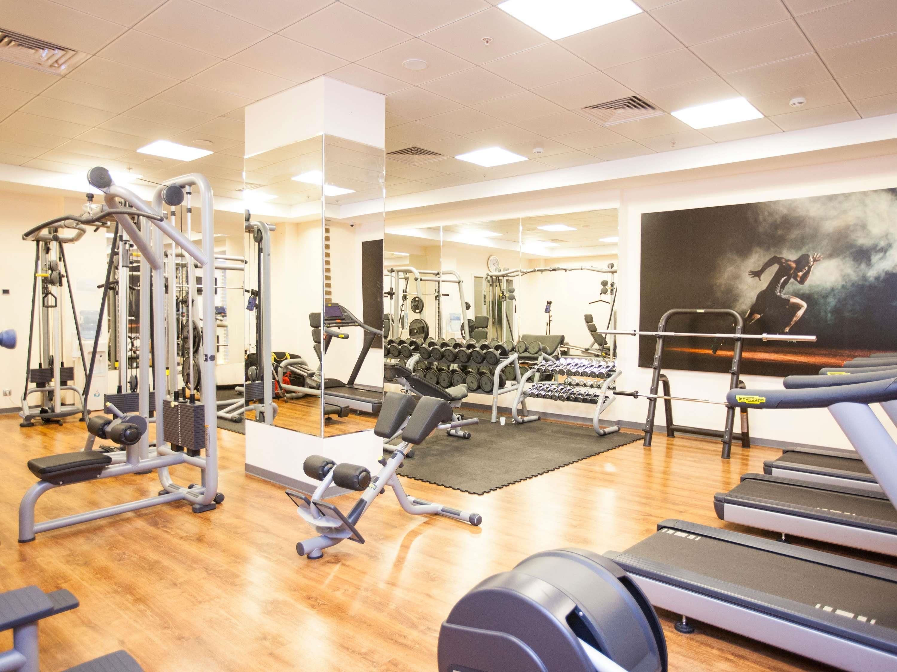 A gym with cardio equipment, weight machines, and free weights.