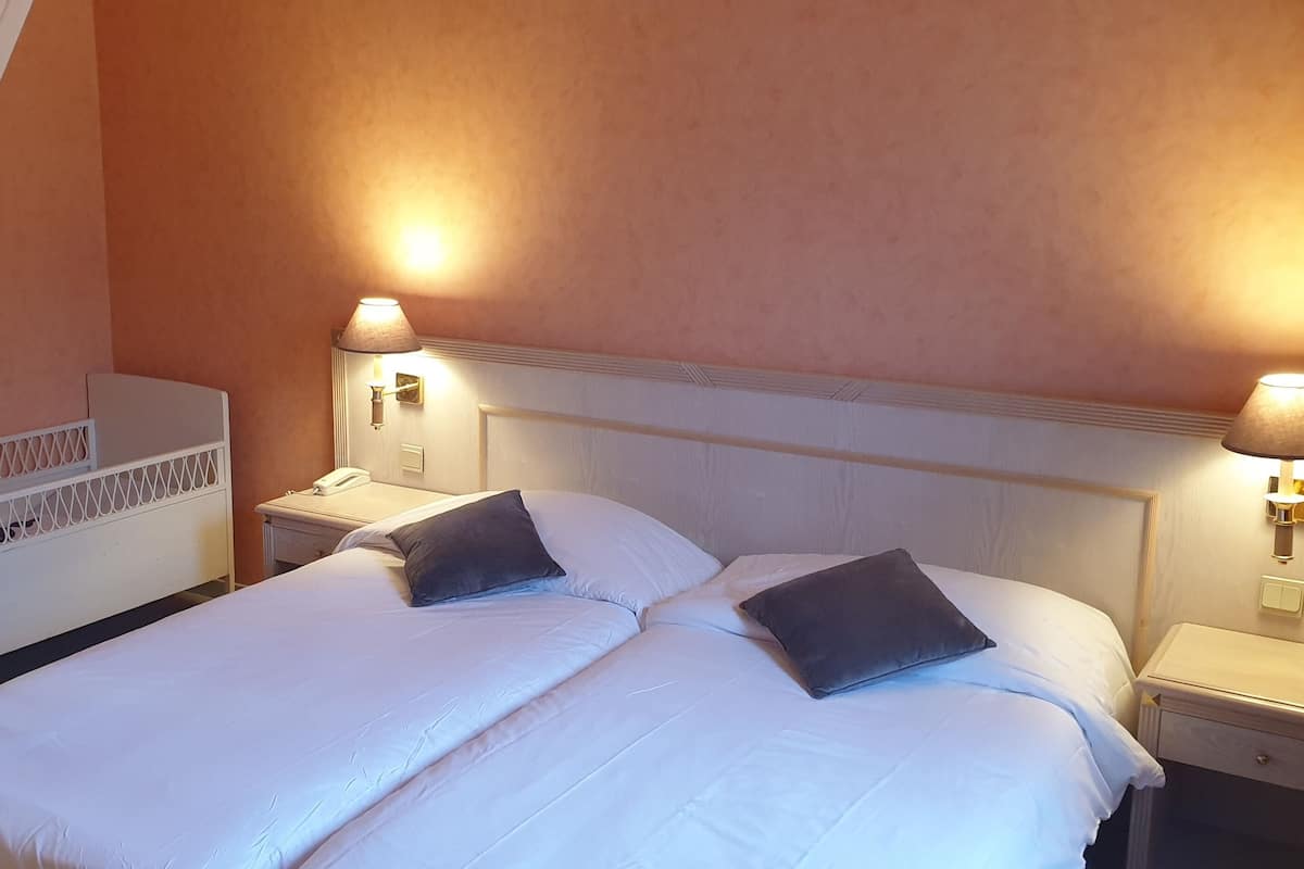 Habitació d'hotel amb un llit, dues taules de nit i una escala.