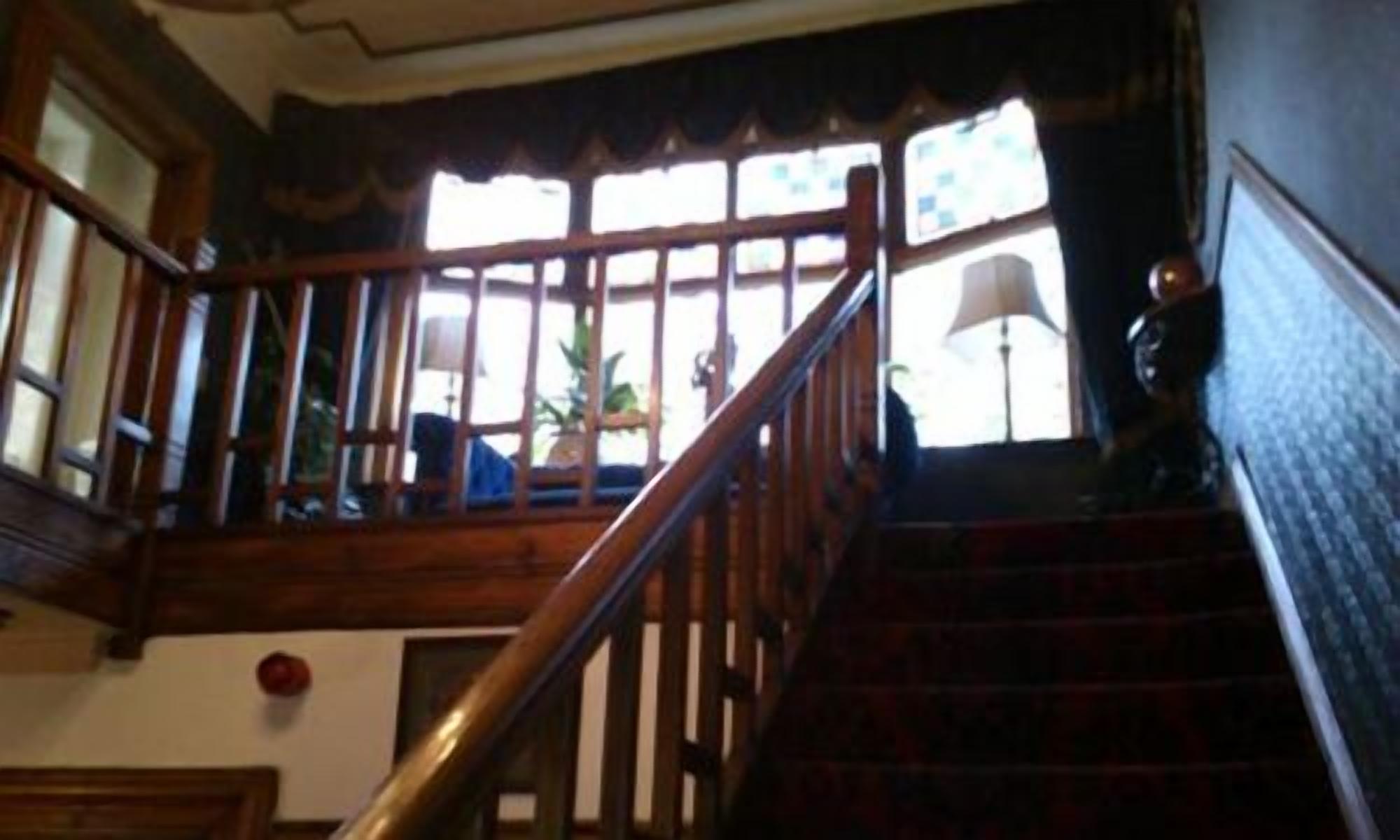 Una escalera de madera con barandilla que conduce a una zona de descanso.