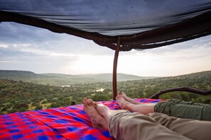 Guests can rest under a simple shelter with a scenic view of the surrounding hills and water.