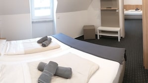 A hotel room with a bed, a small desk, and a wardrobe. - Hotel Kriemhilde (Worms)