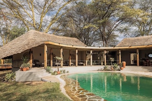 Una piscina al aire libre, sombrillas, tumbonas