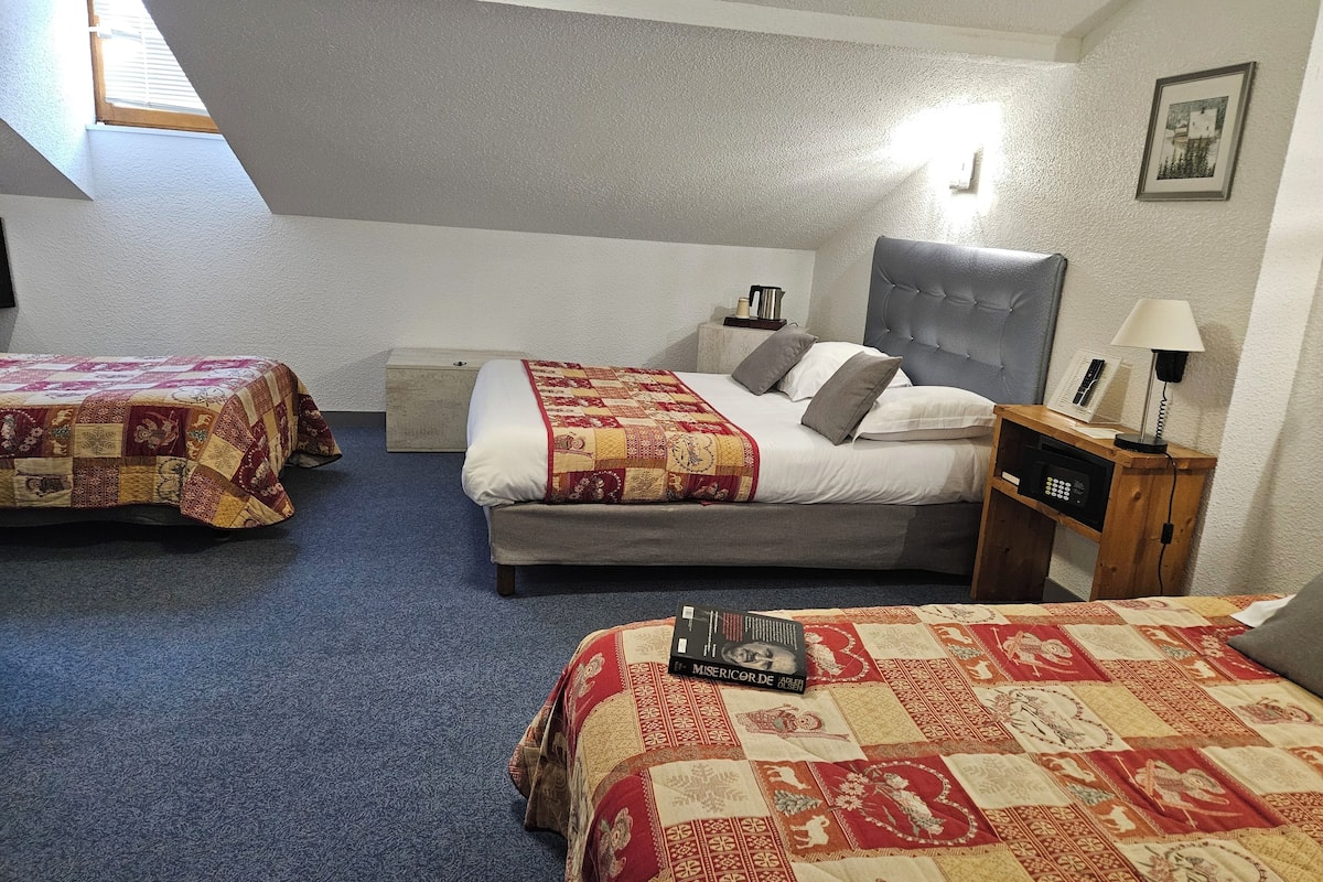 Ein Schlafzimmer mit zwei Betten, einem Nachttisch, einer Lampe und einem gerahmten Bild an der Wand.