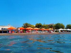Una playa cerca, sillas reclinables de playa, sombrillas