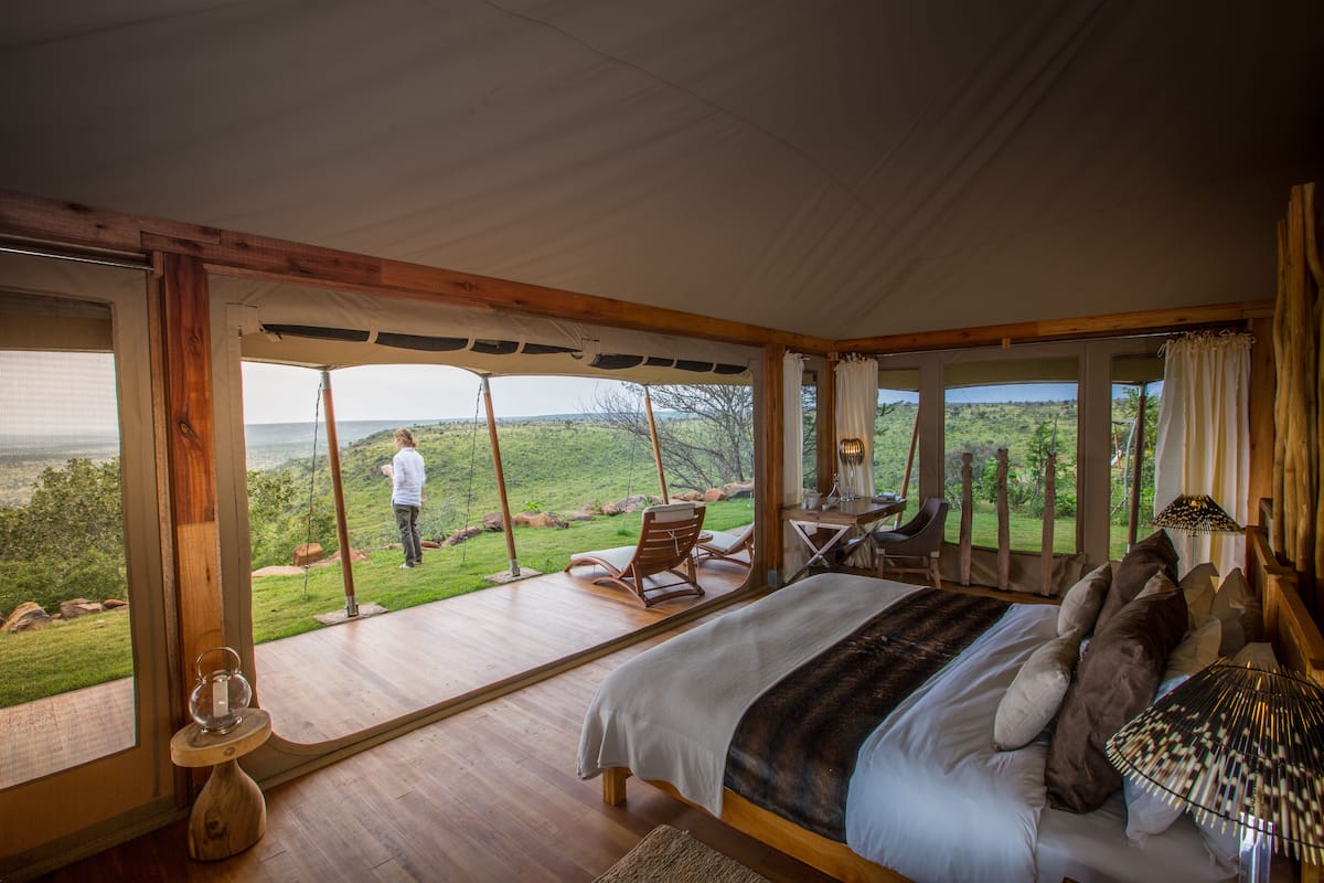 Une chambre avec un grand lit, un plancher en bois et une vue sur l’extérieur.