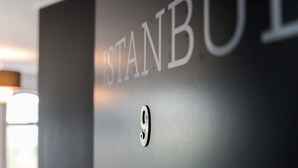 Un gros plan d’un mur sur lequel on aperçoit partiellement le mot « STANB », ce qui pourrait indiquer un nom de lieu ou d’hôtel.