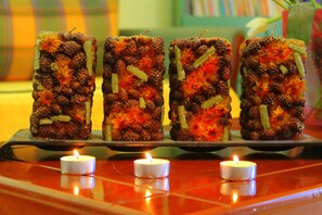 Four candle-lit desserts on a tray. - Tzaneria Apartments (Skiathos)