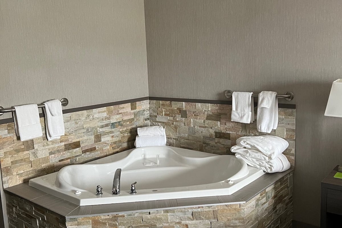 suite, 1 king bed, jetted tub | 1 bedroom, desk, iron/ironing board, free wifi