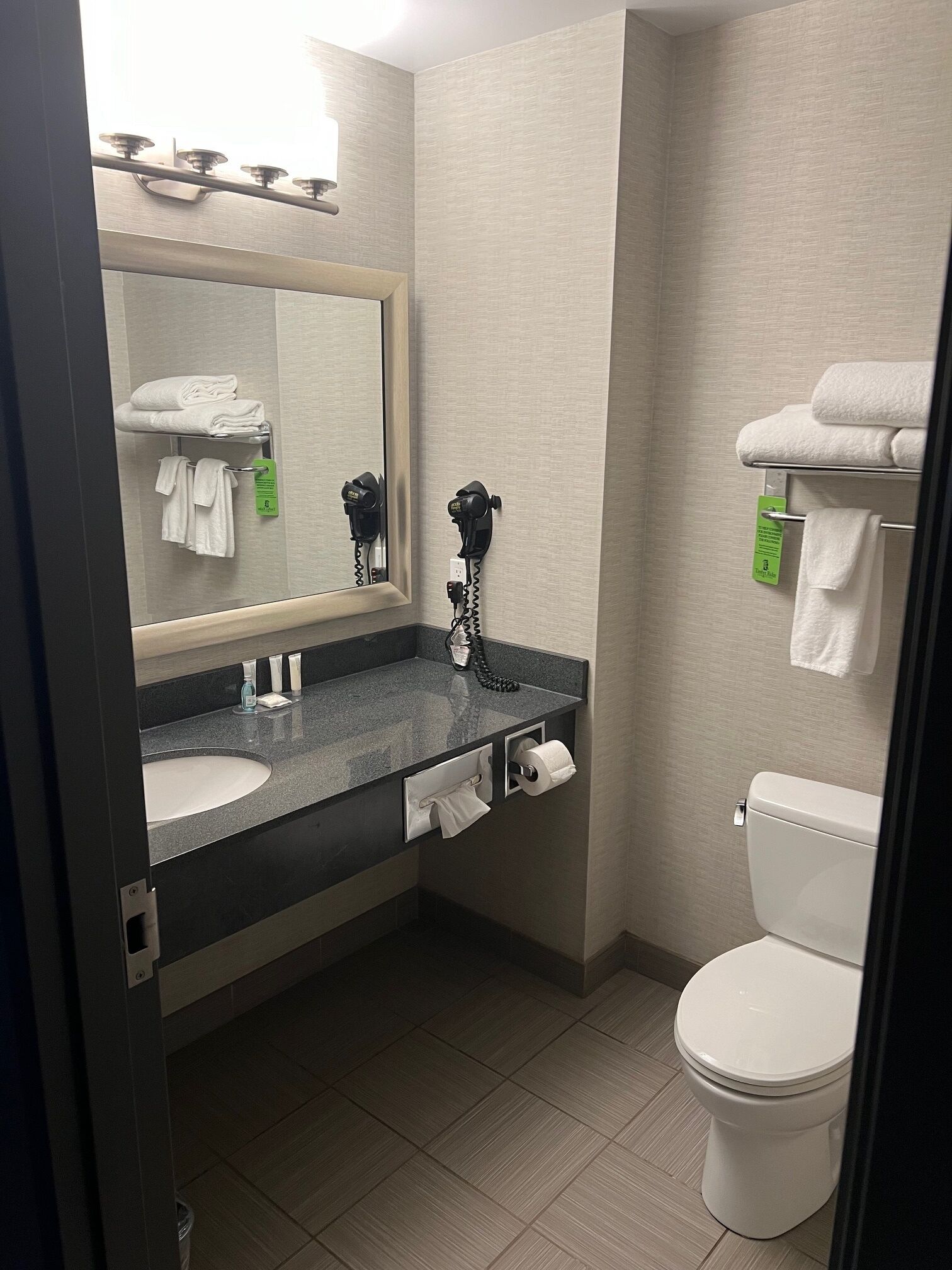 A bathroom with a sink, mirror, towel rack, and toilet.