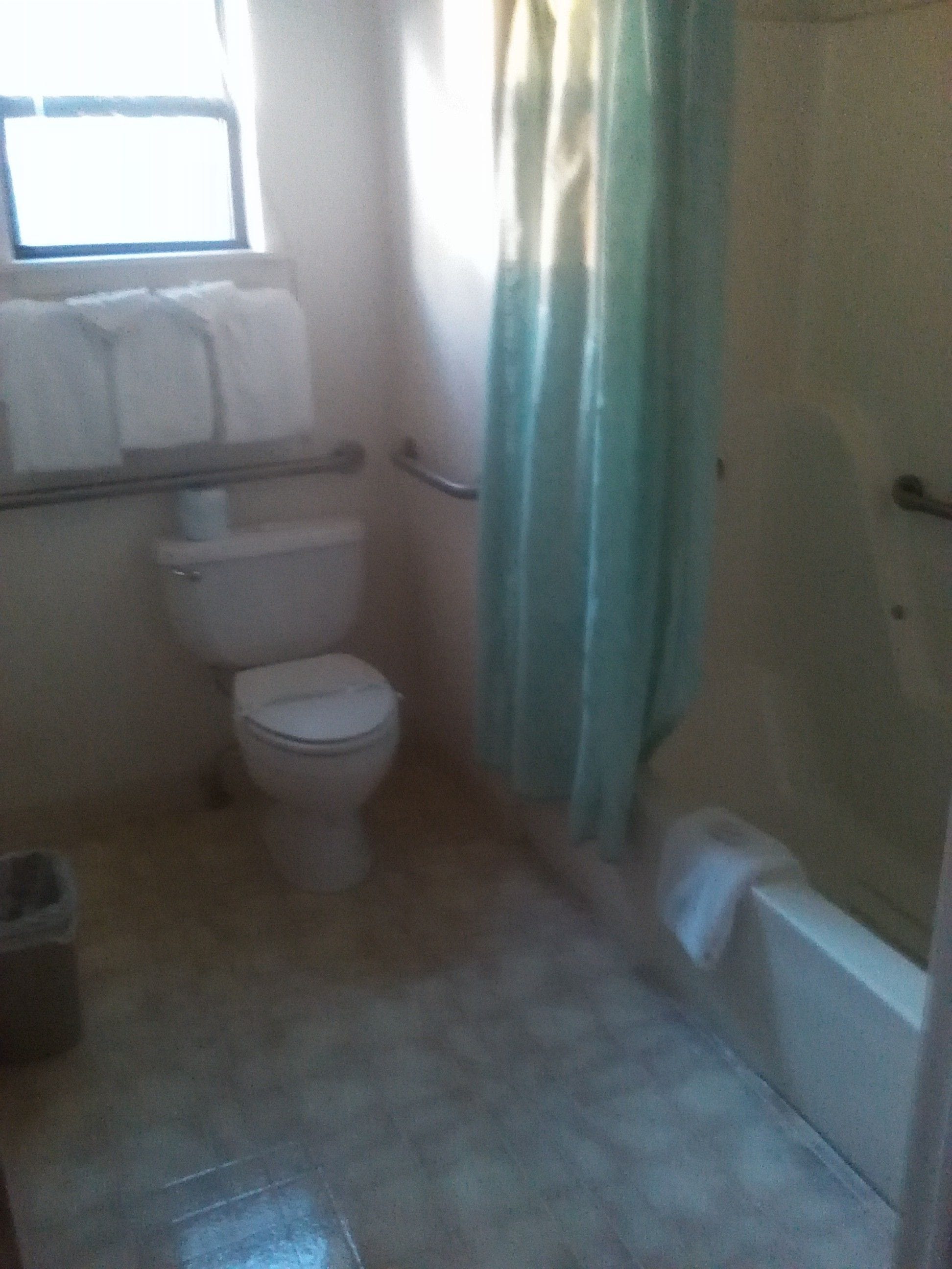 Un baño pequeño con inodoro, bañera y cortina de ducha.
