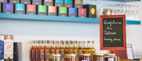 A display of various jars of preserves and a chalkboard sign with the text "Confetures du Patron Service-Paris".