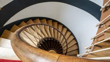 A spiral staircase with wooden steps and a metal handrail.