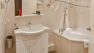 A modern bathroom with a double sink, a bathtub, and a shower. There is a mirror above the sink and a towel rack above the bathtub.