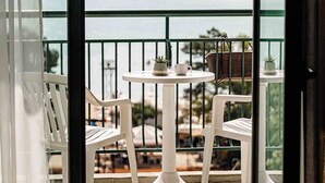 A balcony with a view of the sea, white chairs, a small table, and a basket. - Palm Beach Hotel- All Inclusive (Golden Sands)